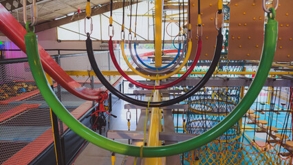 Fototapeta premium Indoor Adventure Park Obstacle Course featuring Colorful Hanging Ropes and Physical Training Equipment for Active Recreation and Fitness