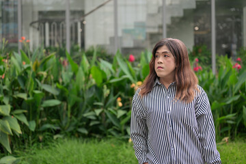 Fototapeta premium Thai Isan transgender businesswoman in 40s looking away thoughtfully outdoors