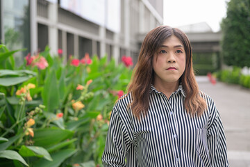 Fototapeta premium Thai Isan transgender businesswoman in 40s looking away outdoors