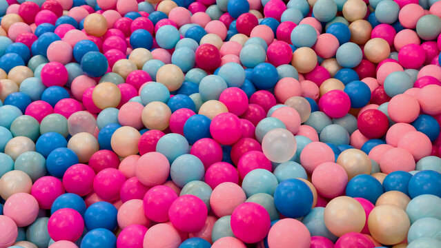 Colorful plastic balls in a playground ball pit for kids play area background texture