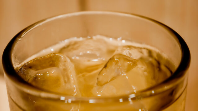 Close up of a Glass Filled with Refreshing Iced Ocha Drink Against a Warm Background
