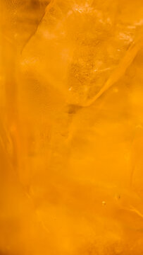 Abstract Macro Close-up of the Translucent Golden Orange Frozen Ice Crystal Texture of Ocha Drink