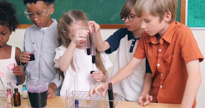Diverse young children conduct a colorful chemistry experiment using test tubes and pipettes in a classroom.
