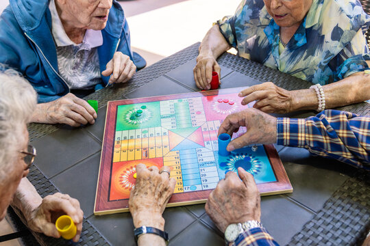 Senior citizens enjoying a board game for leisure and mental stimulation, fostering social connection and activity in retirement