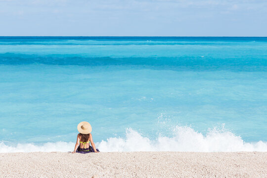 Woman with a straw hat on famous Myrtos beach, Kefalonia, Greek Islands, Greece