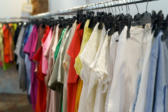 Assorted Vintage and Second Hand Clothing on Hangers in a Thrift Store