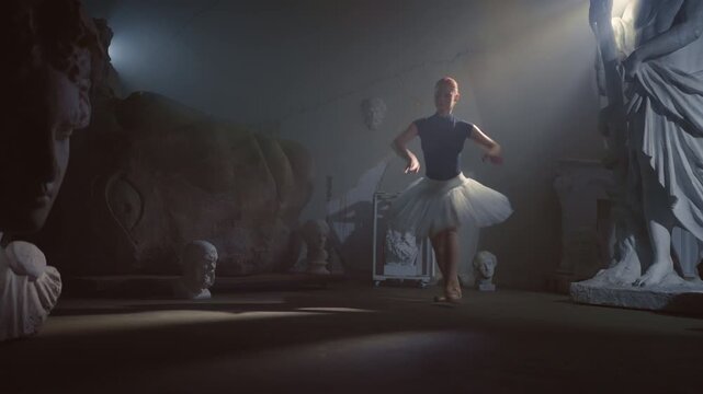 Talented ballerina performing jump in dark museum hall, female grace and beauty. Beautiful woman in tutu and pointe shoes dancing alone, performing ballet choreography, contemporary art performance