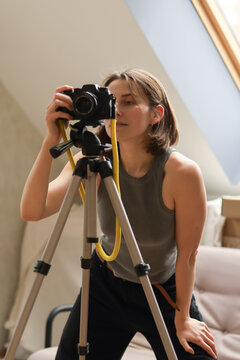 Young woman photographer taking photo with mirrorless camera on