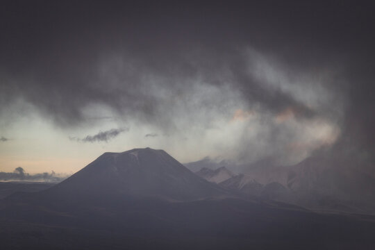 Dramatic storm clouds rolling over mountain peaks