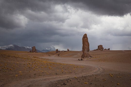 Tall rock monoliths under a stormy desert sky