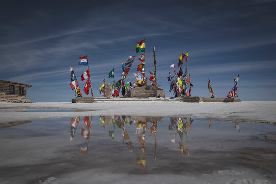 International flags monument reflecting in Bolivian salt flats