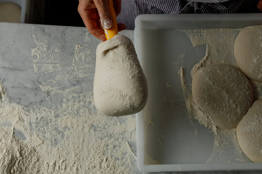 Pizza maker takes pizza dough out of the mold