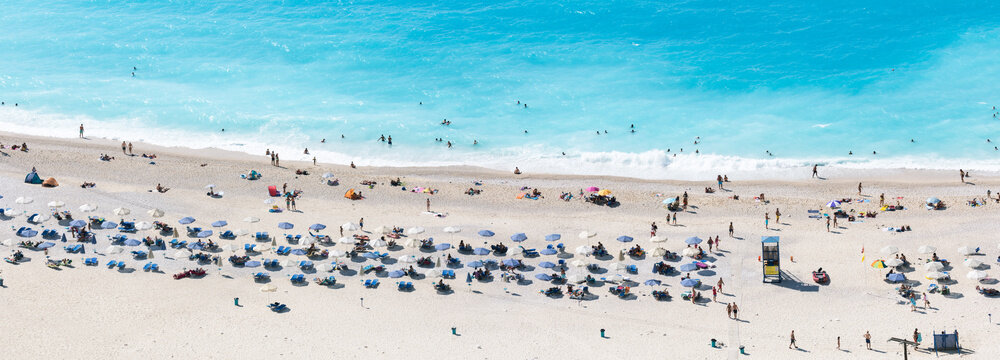 Aerial view of famous Myrtos beach with umbrellas, Kefalonia, Greek Islands, Greece