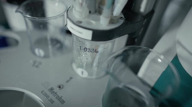 A close-up shot of a medical specimen cup being used in a professional laboratory testing environment. The footage highlights careful sample handling and diagnostic procedures within a clean, sterile