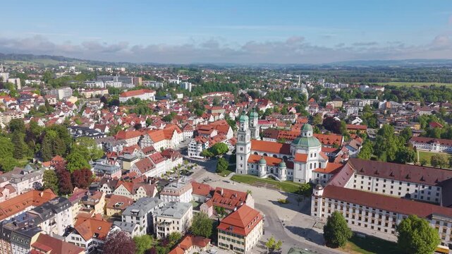 Rising drone shot of Basilica Saint Lorenz Church and the historic Kempten Allg&auml;u city center in Germany, showcasing Bavarian architecture and the urban landscape from above. UHD.