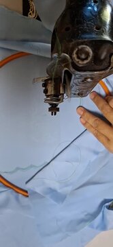Hands Embroidering Hemline Design on Garment Using Embroidery Machine