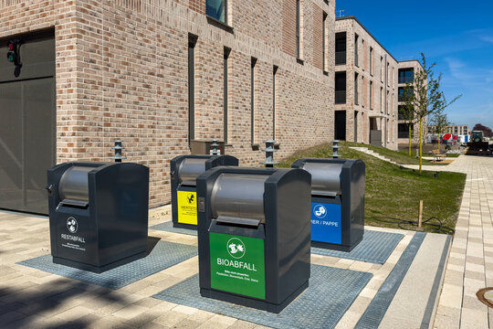 Recycle bins located outside a building in a city on a sunny day