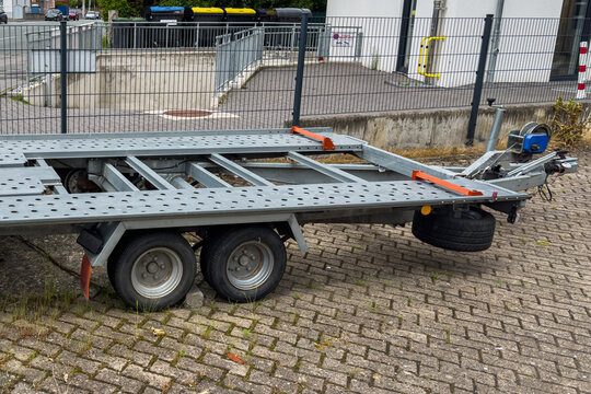 Trailer parked on pavement near a building in an urban area