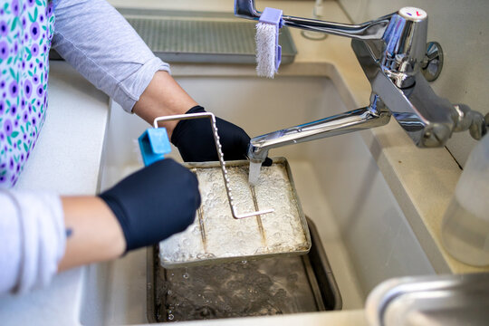 Dental Instrument Sterilisation Tray Being Scrubbed at Sink