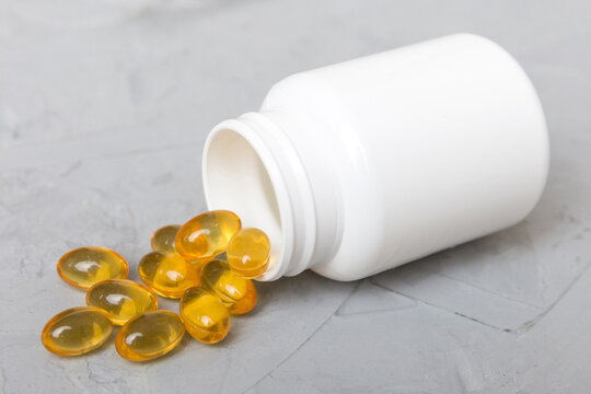 Omega-3 capsules lie in white bottle on a table background. Fish oil tablets top view. Biologically active additives. omega 6, omega 9, vitamin A, E, vitamin D, vitamin D3, evening primrose oil