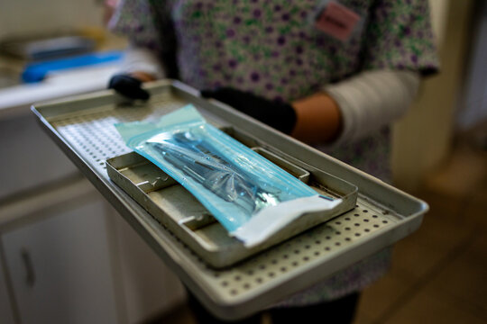 Dental hygienist carrying sterilised instruments on a clinic tray