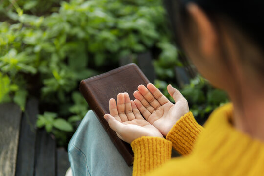 The young woman is praying. Concepts of offering prayer and praise to God. prayer and praise with the Bible.