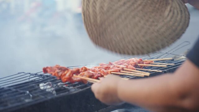 Vendor Grilling Chicken Barbecue at Street Food Stall with Smoke