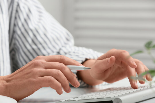Young female programmer with computer typing on keyboard in office, closeup