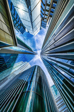 Looking directly up at the skyline of the financial district in central London, modern architecture as a background