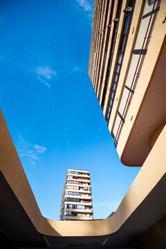 Curved courtyard walls frame an apartment tower in Benidorm, where blue sky, balconies and highrise residential architecture create upward depth