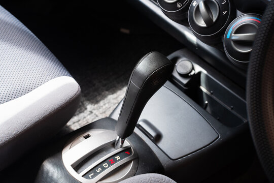Close-up view of an automatic transmission gear selector inside a passenger car, showing gear positions and modern vehicle interior details.