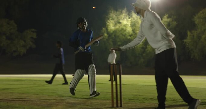 After bowler delivering ball on floodlit pitch, batsman playing offside shot, running single