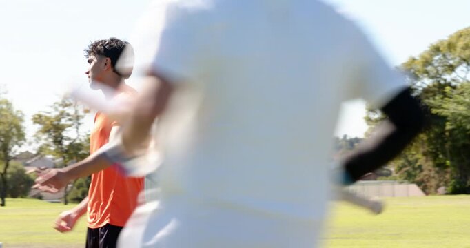 Umpire signaling no-ball after bowler in orange shirt delivering bowl past stumps on pitch