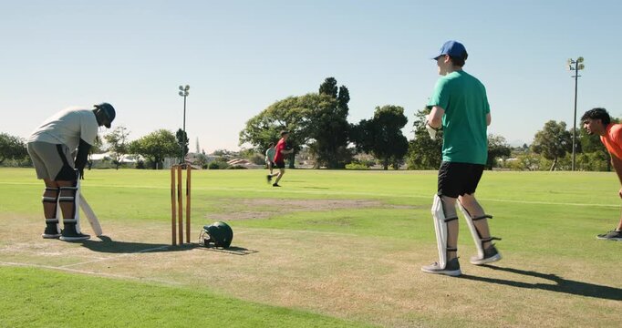 African american batsman tapping bat on pitch triggers keeper catching ball, returning to bowler