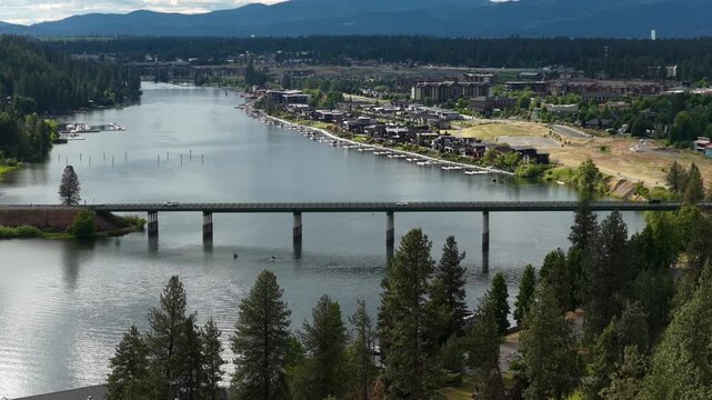 Aerial of Spokane River and urban town in Coeur Dalene Idaho with bridge in spring with mountain view
