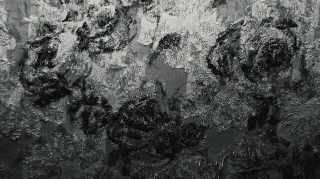 textured black and white floral jacquard fabric ripples gently under dramatic cinematic chiaroscuro studio lighting