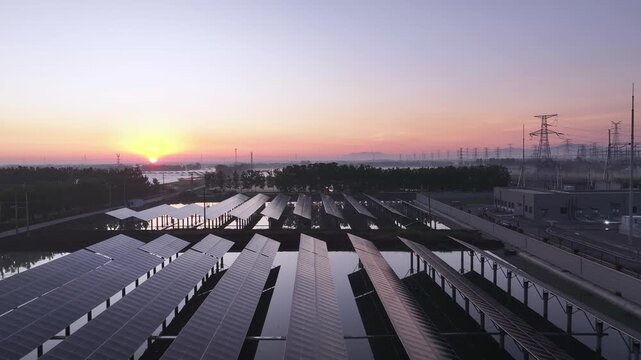 Solar photovoltaic power station on water at sunset with clear reflections and distant transmission towers