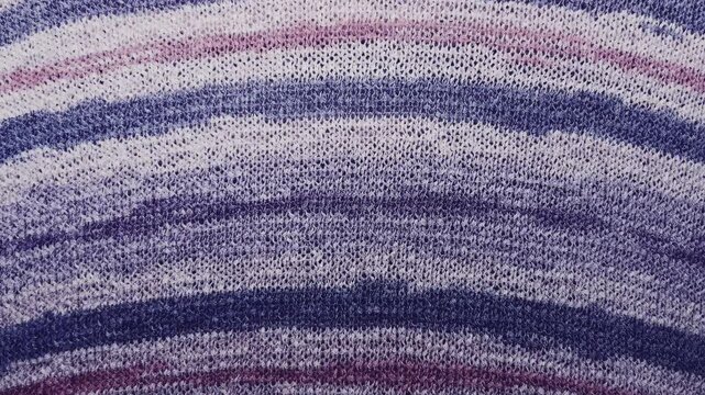 purple knitted fabric texture macro tracking slowly across striped violet wool yarn waves
