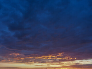 Fototapeta premium Sun rays breaking through dramatic storm clouds at sunset