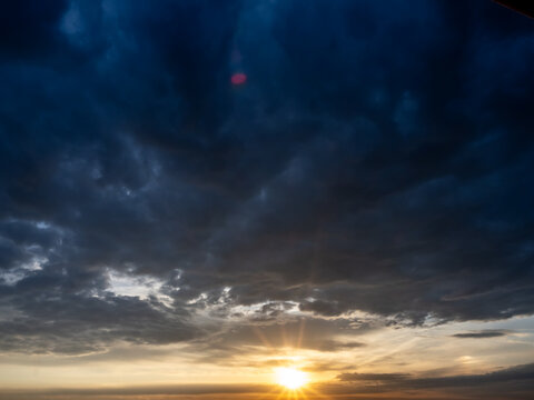 Sun rays breaking through dramatic storm clouds at sunset
