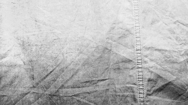 textured monochrome fabric ripples gently as subtle light shifts across raw cotton weave stitching details