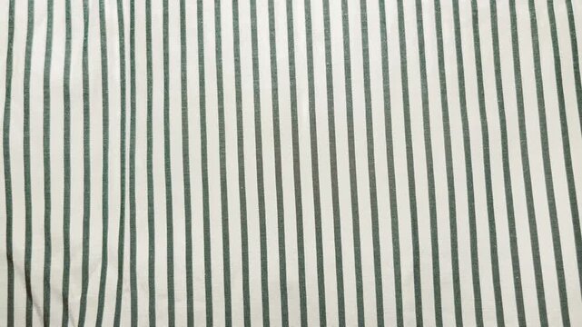 green striped linen fabric sways gently in natural light creating a calm minimalist aesthetic