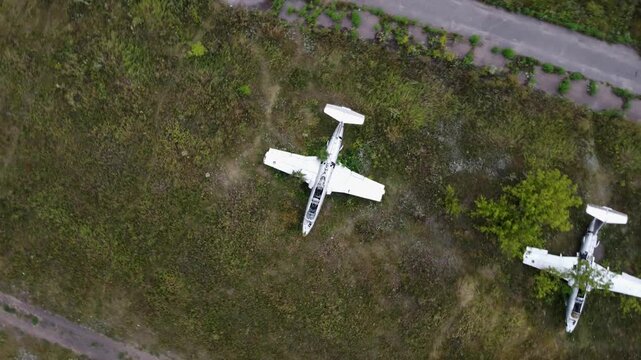 Aerial look down view of abandoned Aero L-29 Delfin trainer aircrafts parked on old overgrown airfield