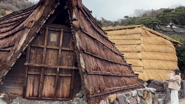 Young female traveler enjoying her vacation sightseeing unique traditional Japanese village architecture in Beppu