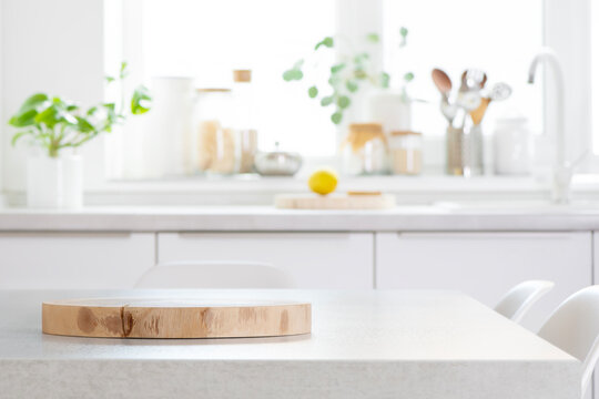 Table top with wooden dish stand or cutting board on blurred kitchen counter background