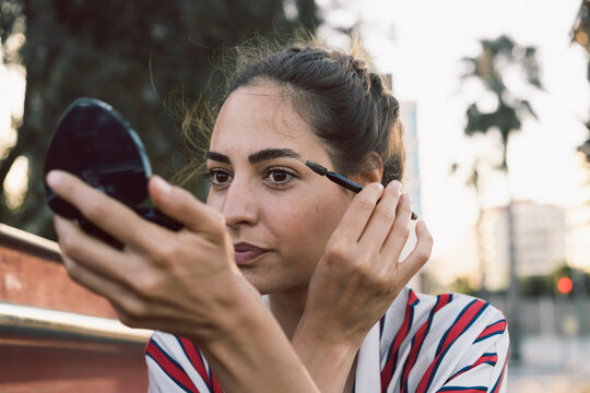 Portrait of woman applying mascara