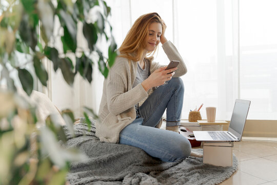 Young woman using smartphone at home