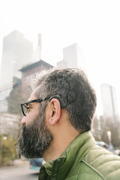 Man with cochlear implant in front of skycrapers, Frankfurt, Germany