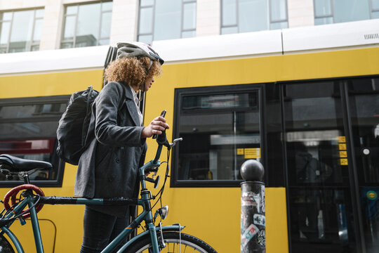 Woman commuting with a bicycle in the city, Berlin, Germany