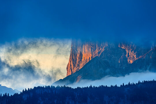 Pic de Bure mountain in alpenglow above a forest in Provence, France